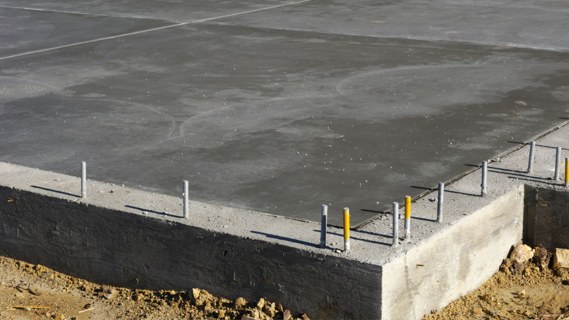 Concrete foundation with metal anchor bolts for construction project